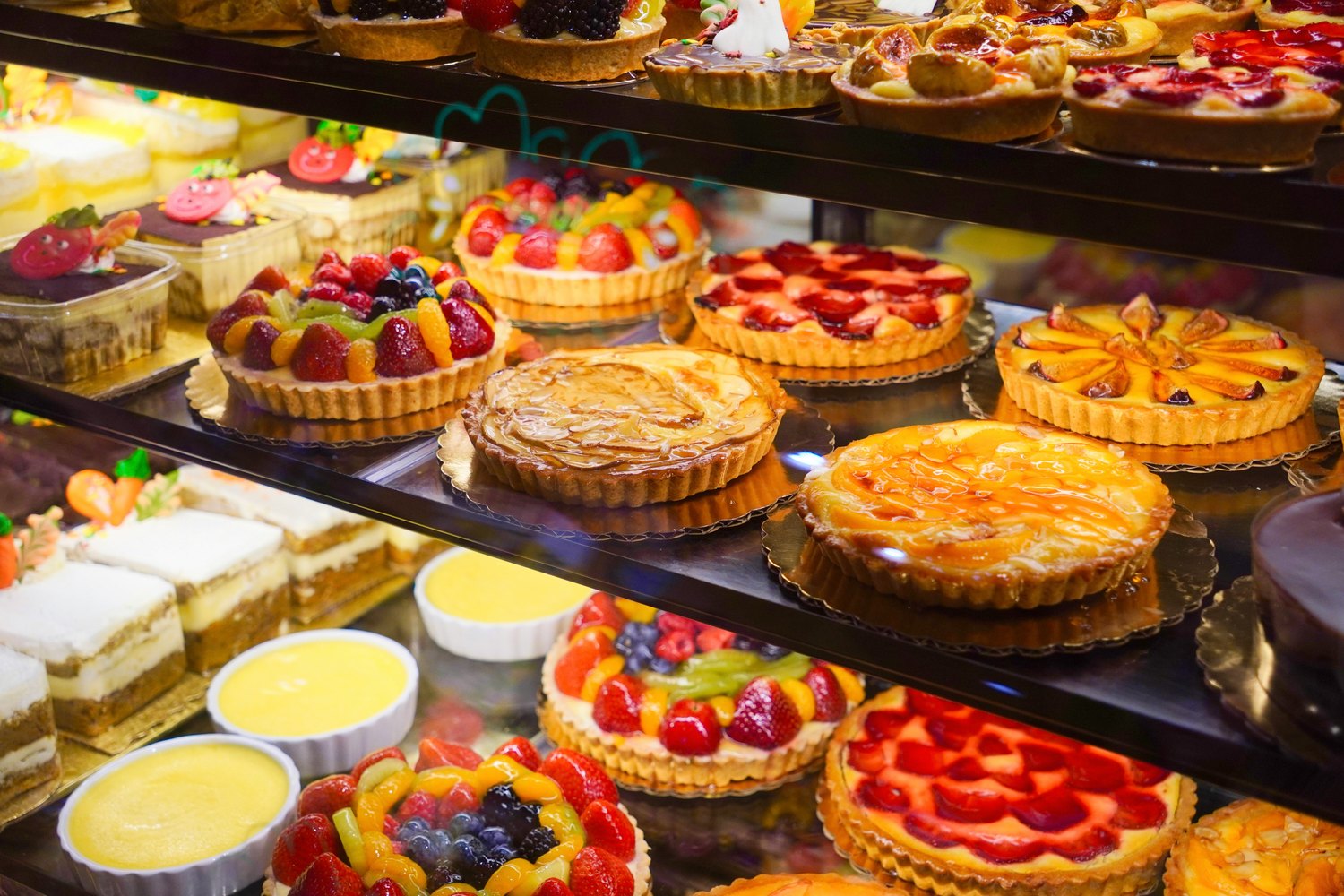 A bakery counter filled with colourful fruit tarts