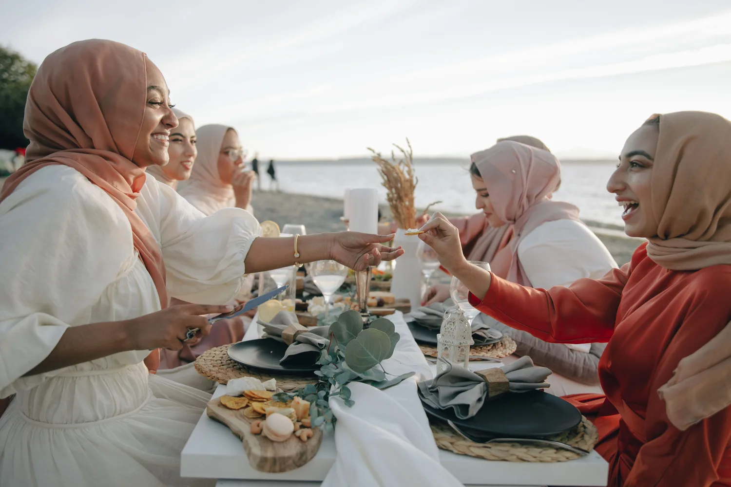 Women sharing a relaxed picnic by the water