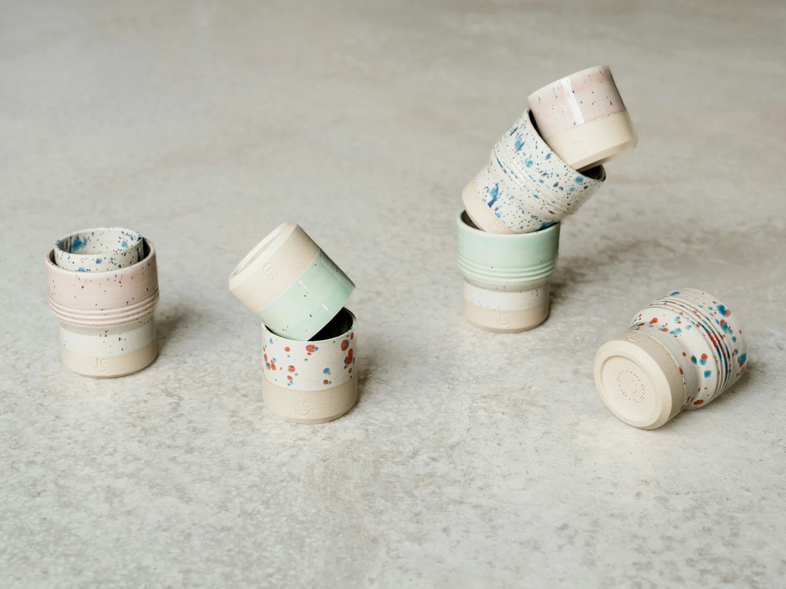 A collection of pastel and speckled ceramic cups