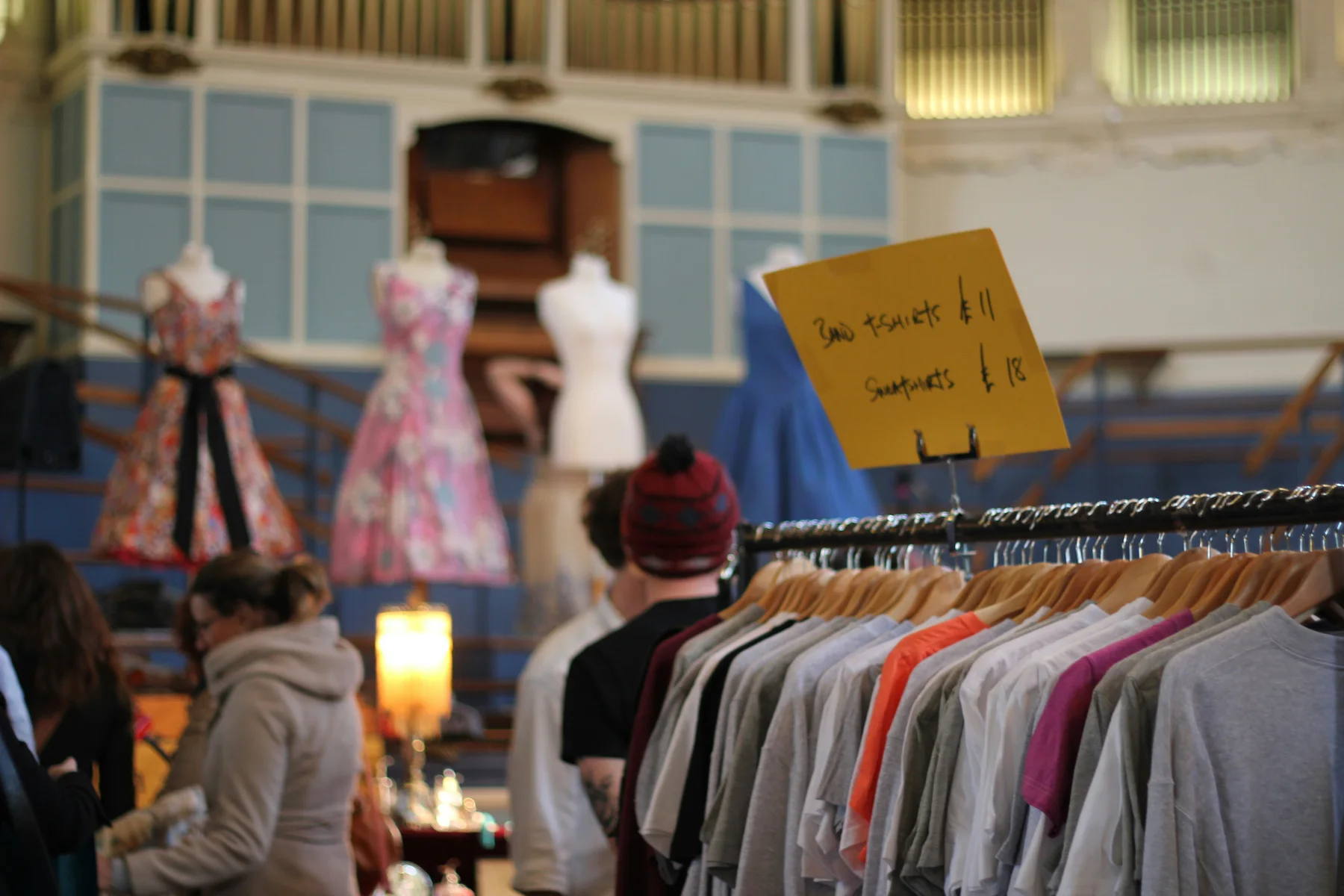Shoppers browsing a secondhand clothing rail